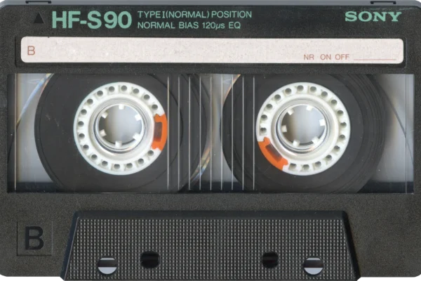 Sony HF-S90 cassette tape with dual reels and orange safety tabs visible against black casing.